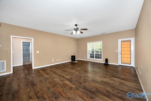 unfurnished living room with baseboards, ceiling fan, and dark wood finished floors