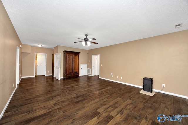 unfurnished living room featuring dark wood-style flooring, baseboards, ceiling fan, and visible vents