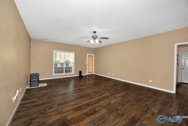 empty room with baseboards, dark wood-type flooring, and ceiling fan