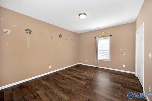 empty room featuring baseboards and wood finished floors