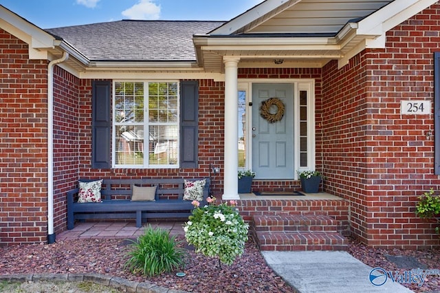 entrance to property with brick siding and roof with shingles