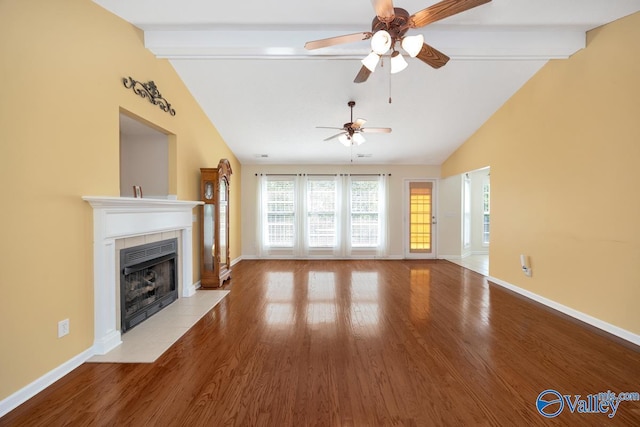 unfurnished living room with a fireplace, ceiling fan, light wood-type flooring, and lofted ceiling with beams