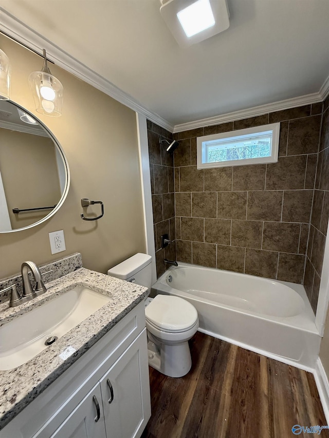 bathroom with toilet, ornamental molding, wood finished floors,  shower combination, and vanity