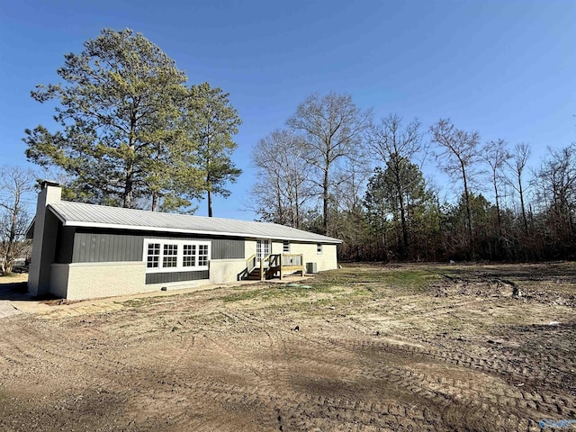 view of front of home featuring metal roof and a chimney