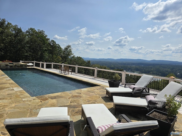 view of swimming pool featuring an outdoor living space, a mountain view, and a patio area