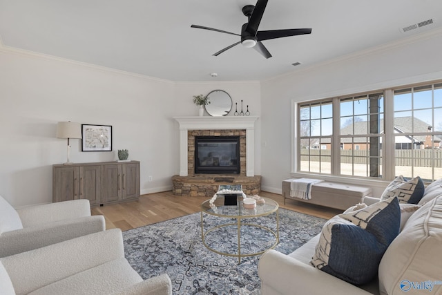 living area with visible vents, baseboards, wood finished floors, and ornamental molding