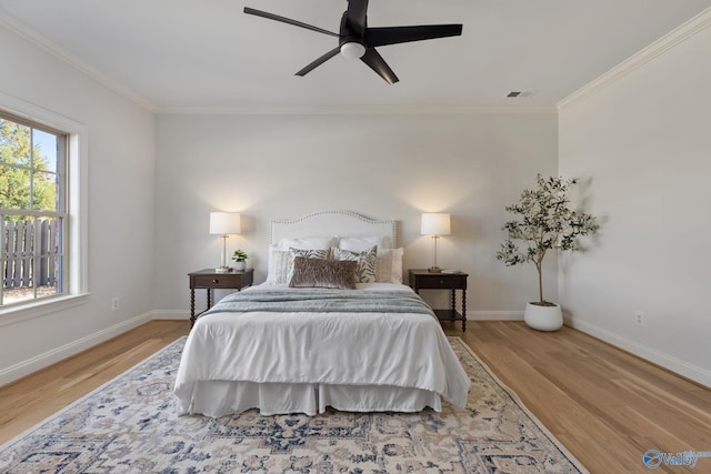 bedroom featuring visible vents, wood finished floors, and crown molding