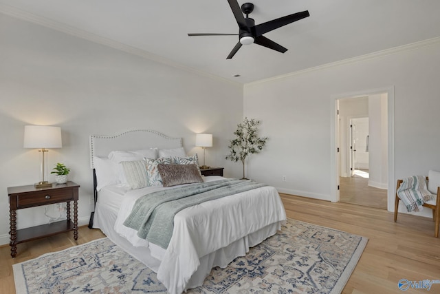 bedroom with a ceiling fan, crown molding, wood finished floors, and baseboards