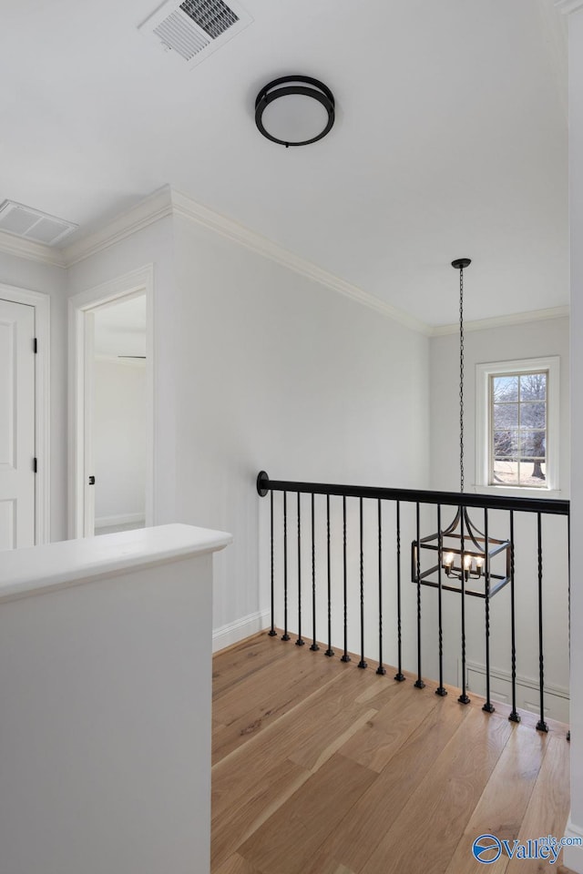 staircase featuring crown molding, wood finished floors, and visible vents