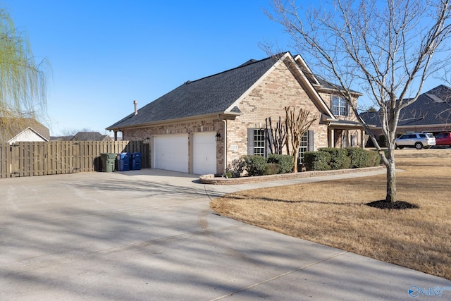 view of home's exterior featuring fence, concrete driveway, an attached garage, a shingled roof, and brick siding