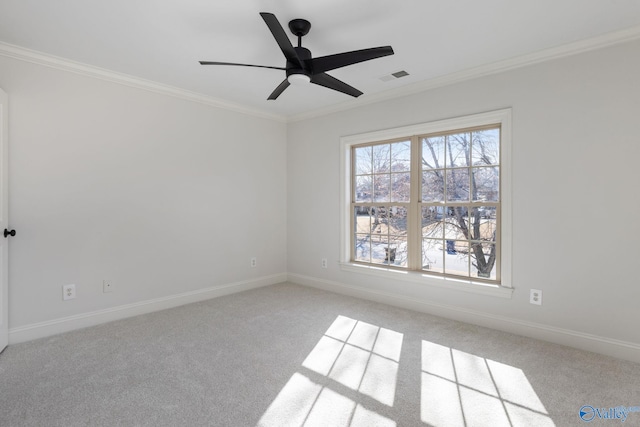 carpeted spare room featuring ceiling fan, baseboards, visible vents, and ornamental molding