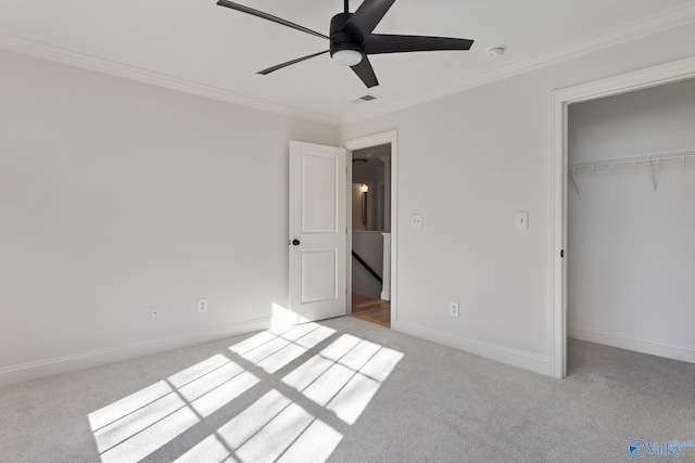 unfurnished bedroom with crown molding, light colored carpet, baseboards, and a closet