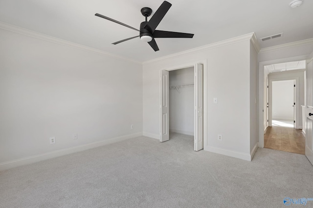 unfurnished bedroom with crown molding, attic access, carpet, and baseboards