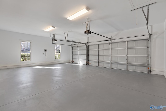 garage featuring a garage door opener and baseboards