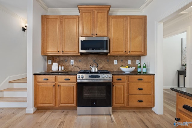 kitchen featuring light wood finished floors, backsplash, and stainless steel appliances