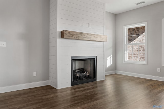 unfurnished living room with dark hardwood / wood-style flooring and a fireplace