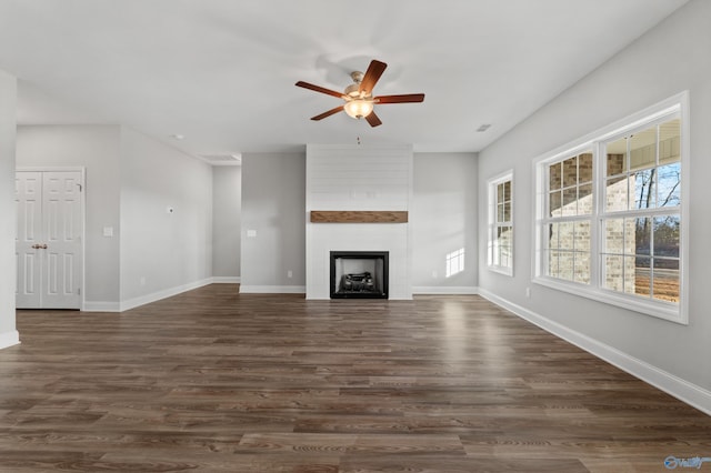 unfurnished living room featuring dark hardwood / wood-style flooring, ceiling fan, and a fireplace