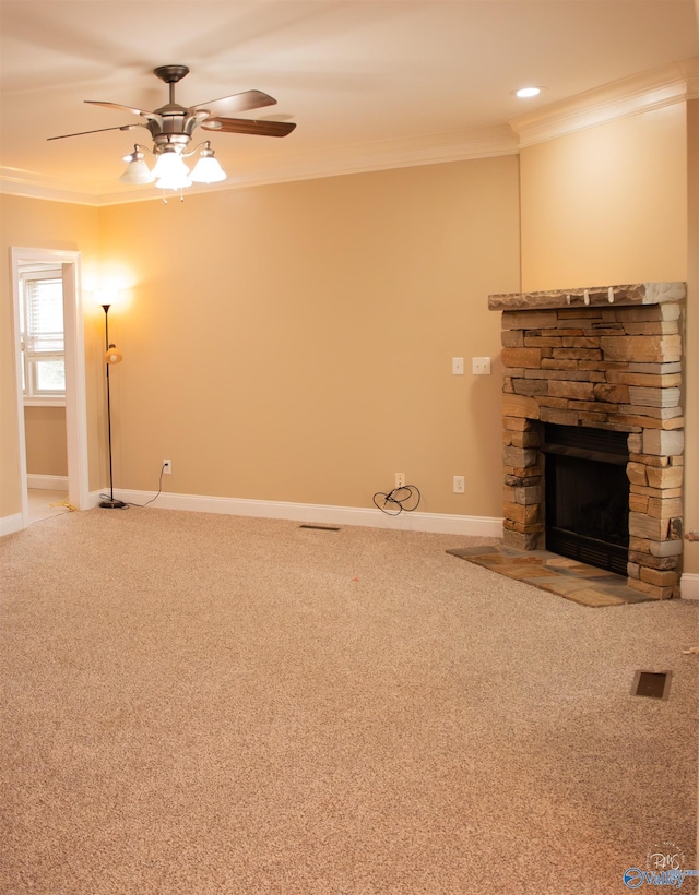 unfurnished living room with carpet flooring, a fireplace, ceiling fan, and ornamental molding