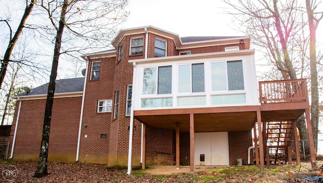 back of property featuring a sunroom and a deck