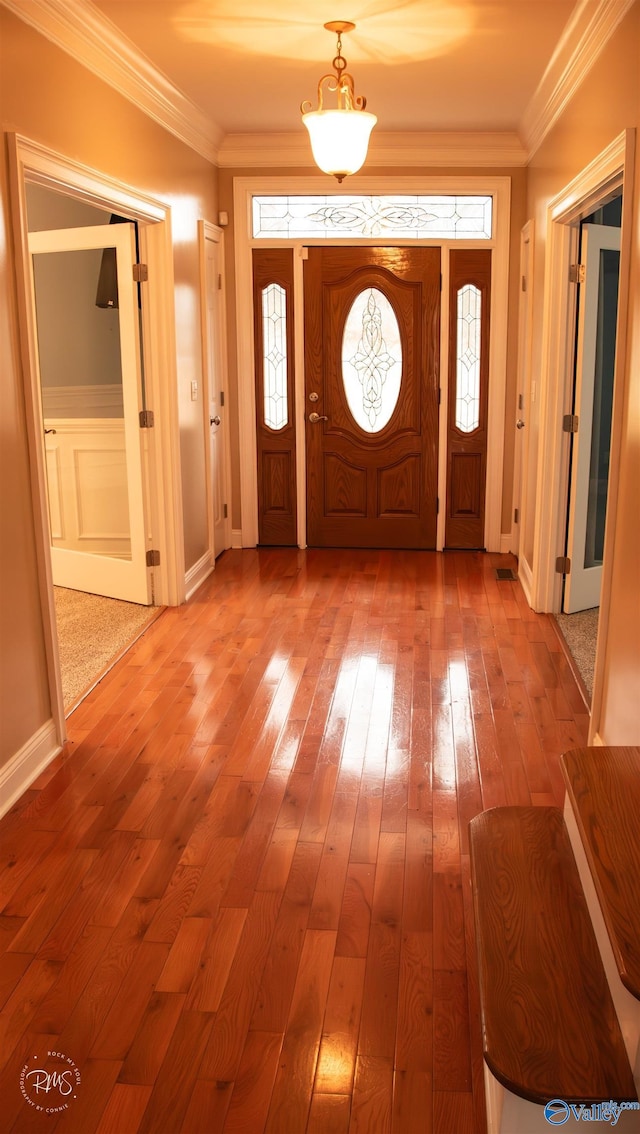 entryway with hardwood / wood-style flooring, plenty of natural light, and ornamental molding