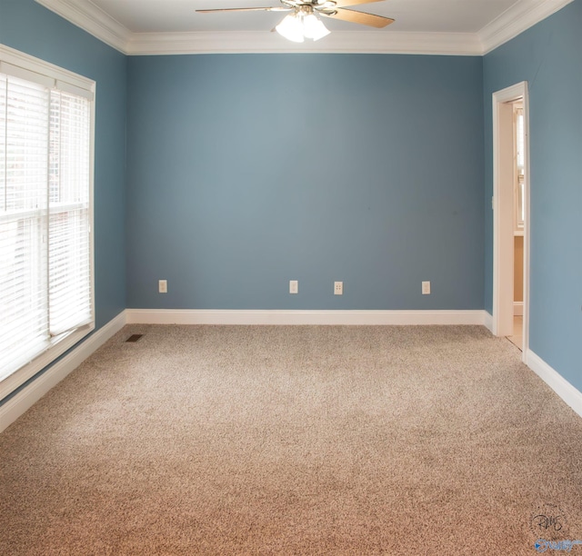 empty room featuring carpet flooring, crown molding, plenty of natural light, and ceiling fan