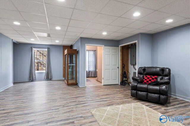 living area featuring hardwood / wood-style flooring and a paneled ceiling