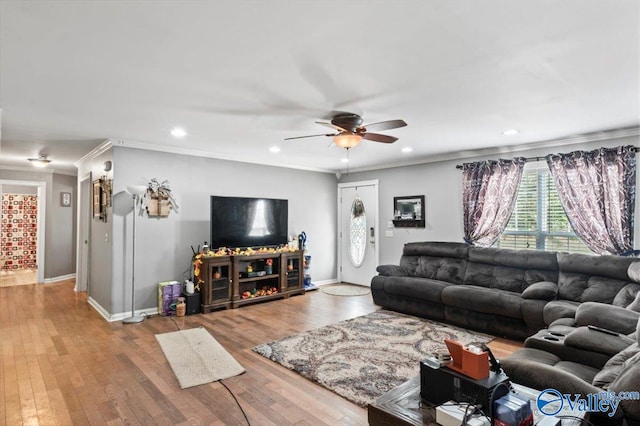 living room with hardwood / wood-style flooring, ceiling fan, and crown molding