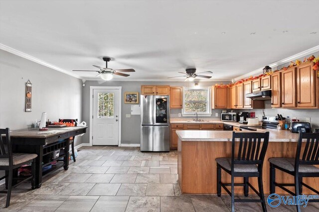 kitchen with kitchen peninsula, plenty of natural light, appliances with stainless steel finishes, and ornamental molding