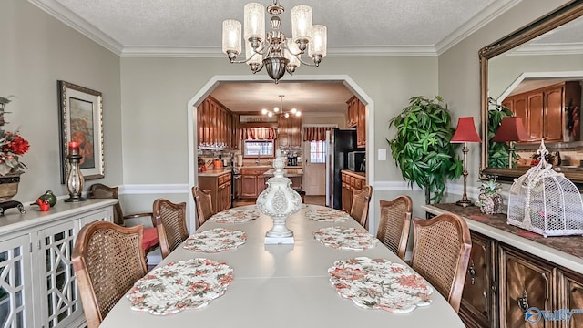 dining room featuring crown molding, a chandelier, and a textured ceiling