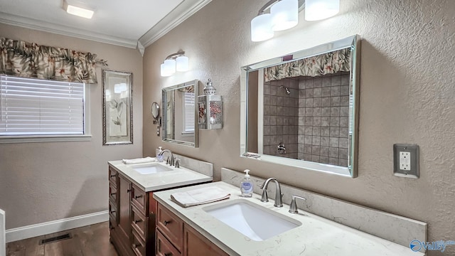 full bath with walk in shower, a sink, visible vents, and crown molding