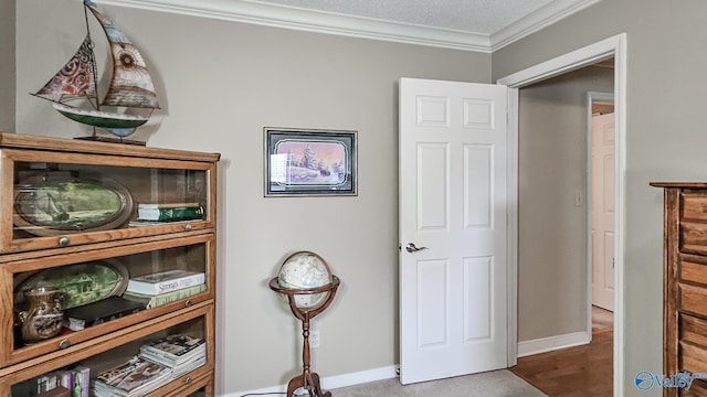 interior space with a textured ceiling, baseboards, and crown molding