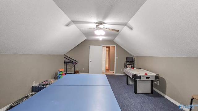 game room featuring lofted ceiling, dark carpet, a textured ceiling, and baseboards