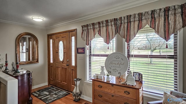 entryway with baseboards, ornamental molding, and wood finished floors