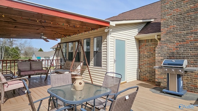 wooden terrace featuring a ceiling fan, outdoor dining area, and a grill