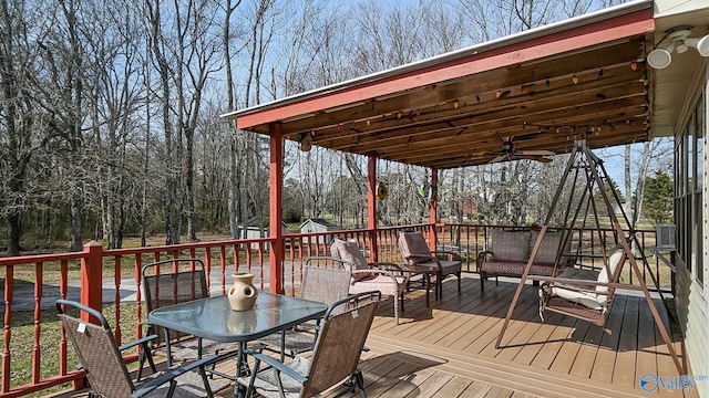 wooden deck with a ceiling fan and outdoor dining space