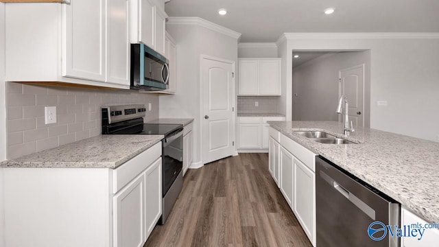 kitchen featuring white cabinets, stainless steel appliances, a sink, light stone counters, and dark wood-style floors