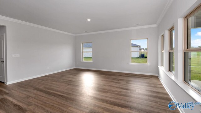 unfurnished room featuring ornamental molding, baseboards, and dark wood finished floors