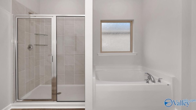 bathroom featuring a bath and a shower stall
