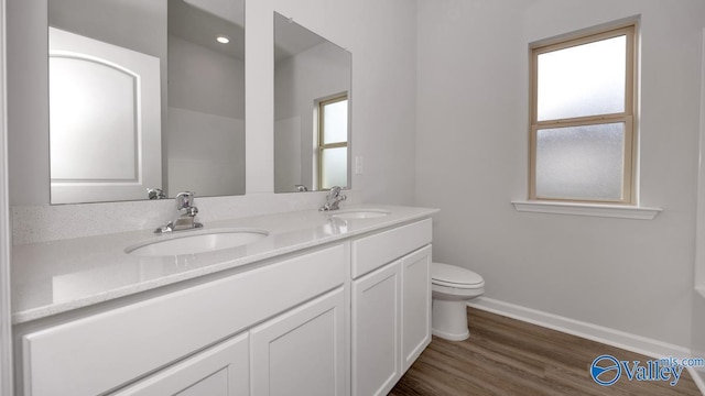 full bath with toilet, a sink, baseboards, and wood finished floors