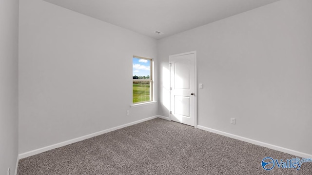 empty room featuring carpet and baseboards