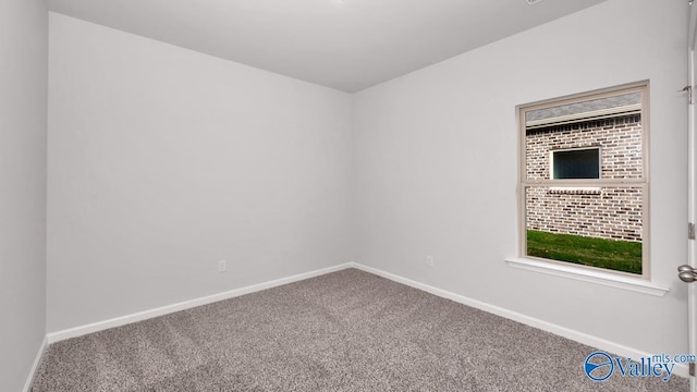 carpeted empty room featuring baseboards