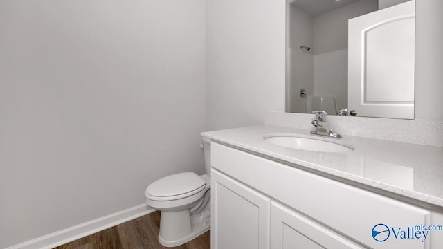 full bathroom featuring walk in shower, baseboards, wood finished floors, toilet, and vanity