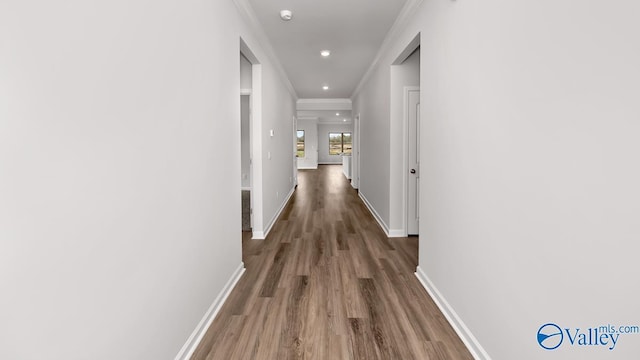 corridor with baseboards, recessed lighting, wood finished floors, and ornamental molding