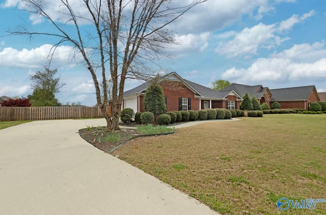 26560 Mill Creek Dr, Athens, AL 35613 - view of front of house featuring concrete driveway, fence, a front yard, brick siding, and a garage
