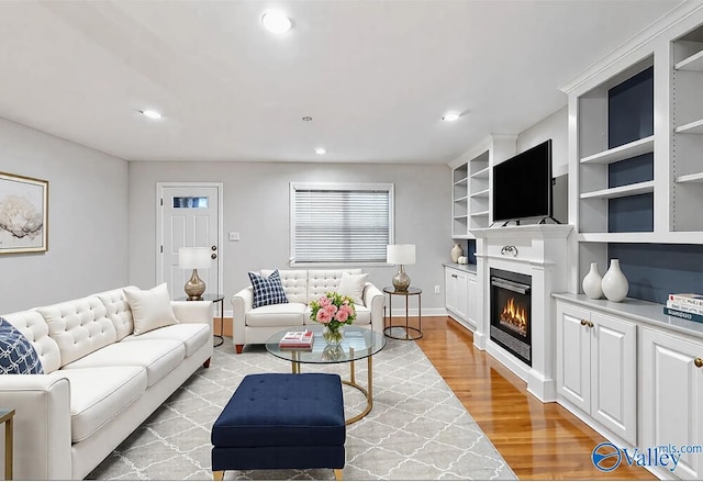 26560 Mill Creek Dr, Athens, AL 35613 - living room with built in shelves, light wood finished floors, a glass covered fireplace, baseboards, and recessed lighting