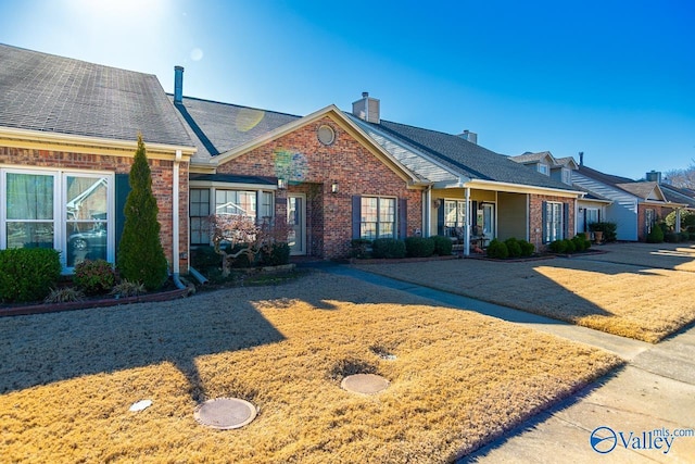 view of front of house featuring brick siding and a chimney