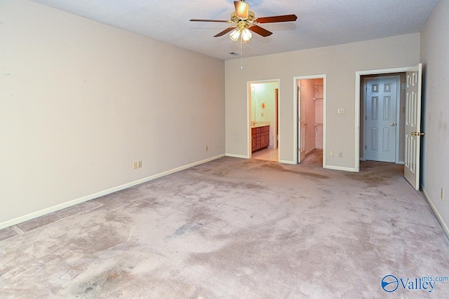 unfurnished bedroom featuring baseboards, a walk in closet, and a textured ceiling