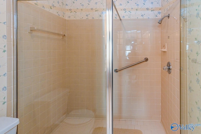 full bath with a shower stall, toilet, and wallpapered walls