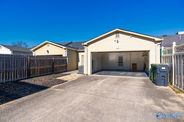 view of front of home featuring concrete driveway, an attached garage, cooling unit, and fence