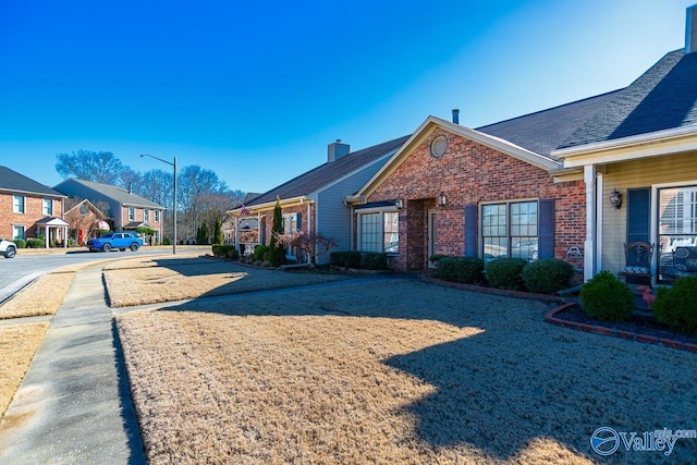 view of side of property with a residential view and brick siding